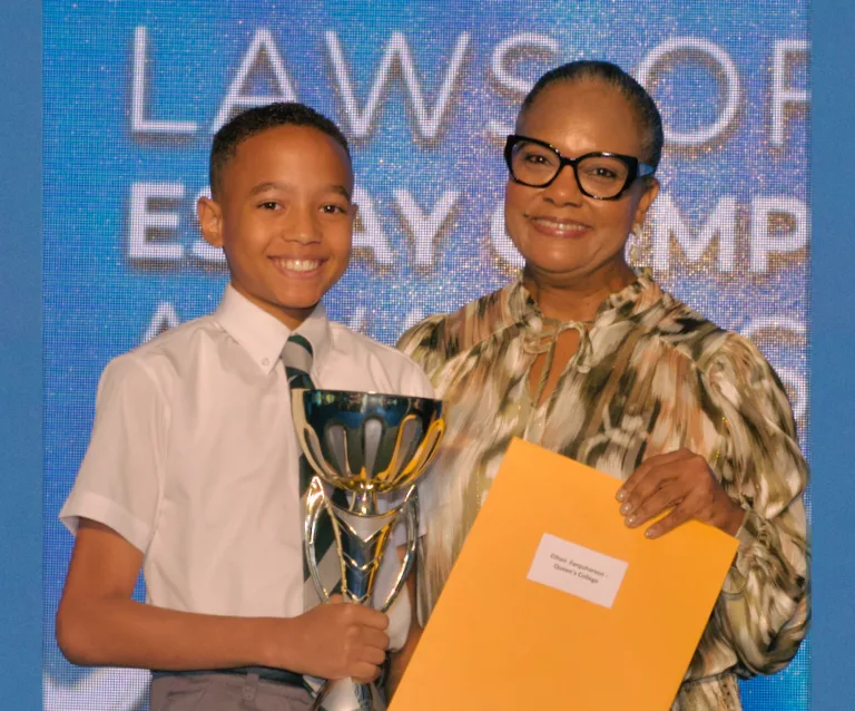 The Bahamas Laws of Life Essay and Video Competition 2024 - Ethan Farquharson of Queen’s College - Top Scorer in Junior Division - Overall Winner of the 2024 Laws of Life Essay Competition Receives his prize from TWCF President, Tina Cambridge.