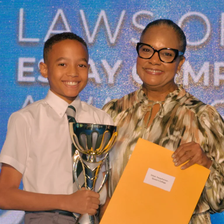The Bahamas Laws of Life Essay and Video Competition 2024 - Ethan Farquharson of Queen’s College - Top Scorer in Junior Division - Overall Winner of the 2024 Laws of Life Essay Competition Receives his prize from TWCF President, Tina Cambridge.